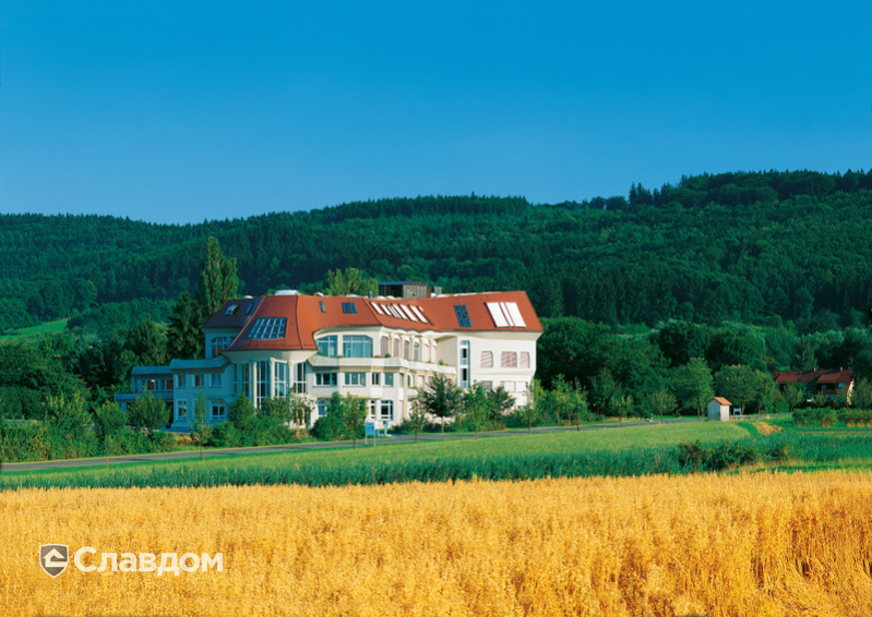 Многоэтажный дом в лесу с крышей из черепицы Creaton Biber Klassik Kupferrot engobiert