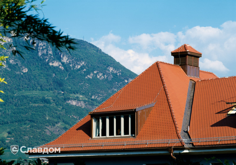 Многоэтажное здание с каменным цоколем с крышей из черепицы Creaton Biber Klassik Naturrot