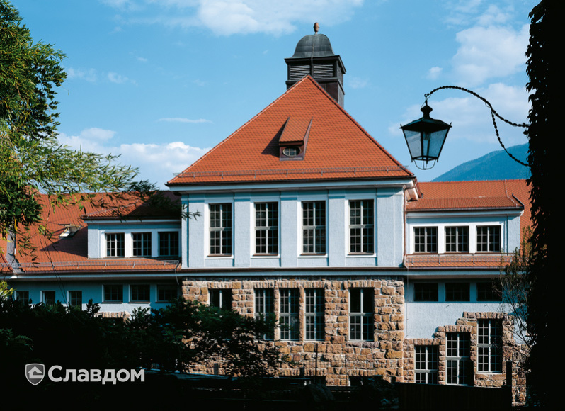 Многоэтажное здание с каменным цоколем с крышей из черепицы Creaton Biber Klassik Naturrot