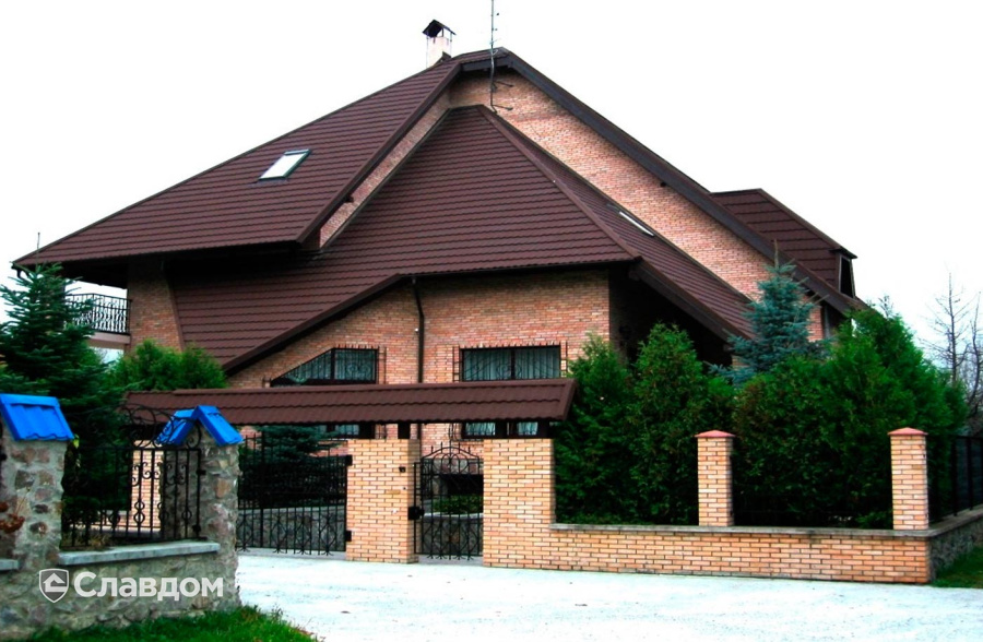 Загородный дом с нестандартной крышей с покрытием из композитной черепицы METROTILE МетроБонд  кофе