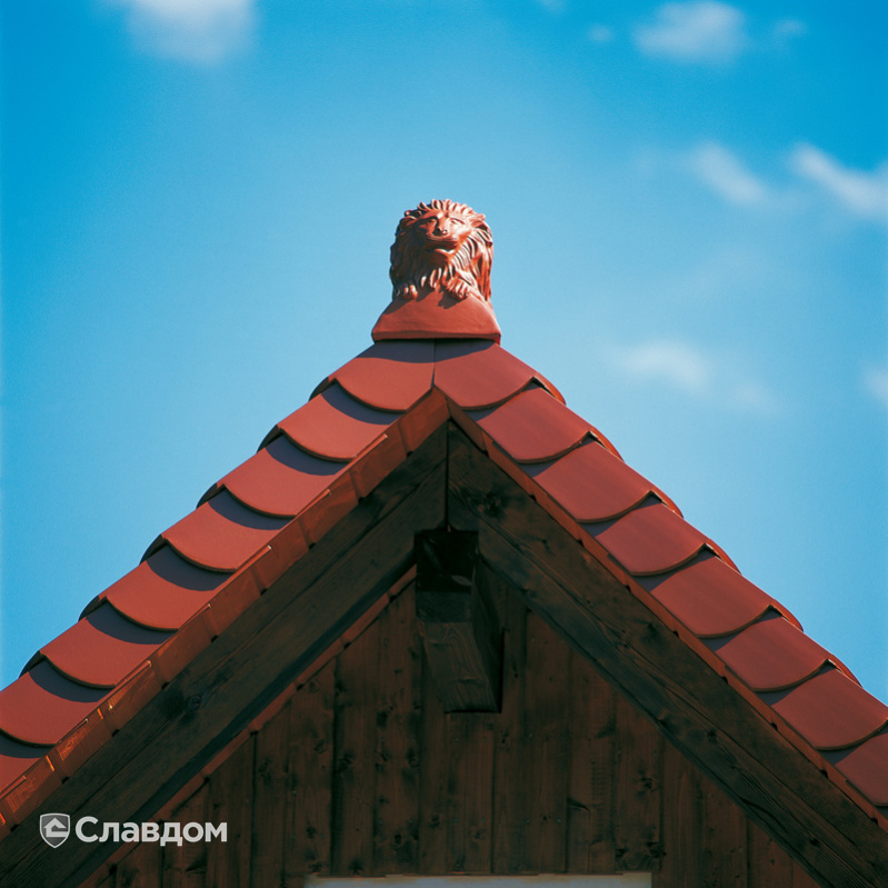 Домик с коньком в виде льва на крыше из черепицы Creaton Biber Klassik Kupferrot engobiert