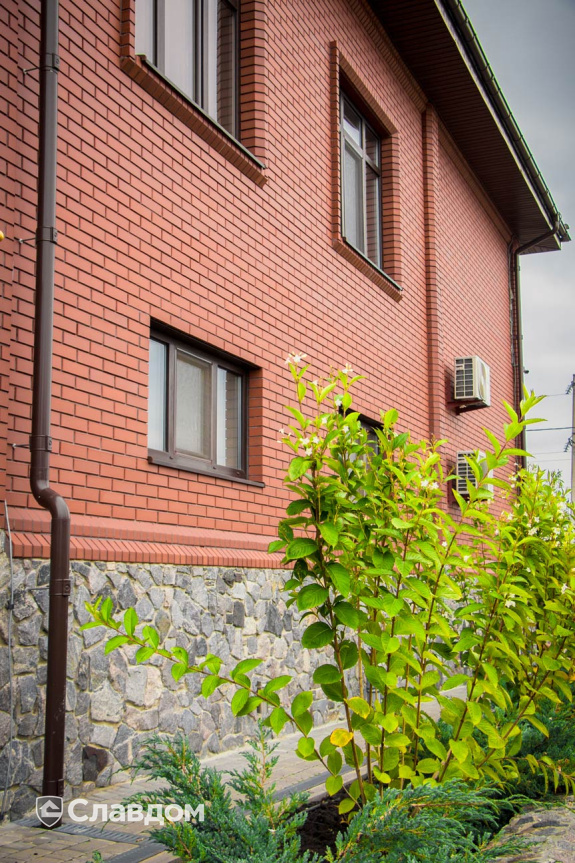 Дом с облицовкой из кирпича Керамейя рубин и натуральным камнем