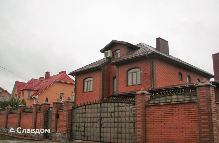 Дом с забором и облицовкой из кирпича Керамейя рубин