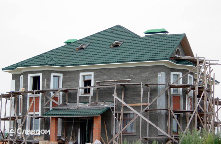 Двухэтажный загородный дом с покрытием крыши из композитной черепицы METROTILE МетроБонд зеленый
