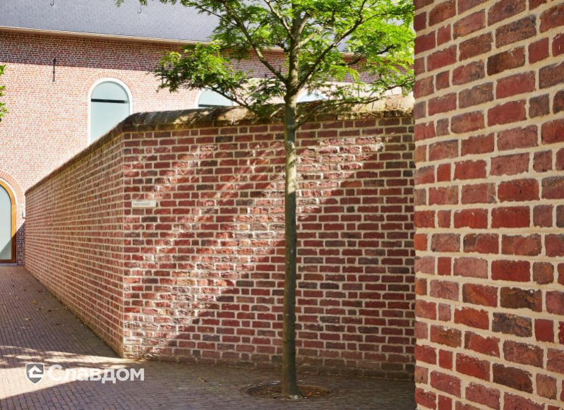 Стена аббатства в Вествлетерене с облицовкой кирпичом Terca Paarsblauw