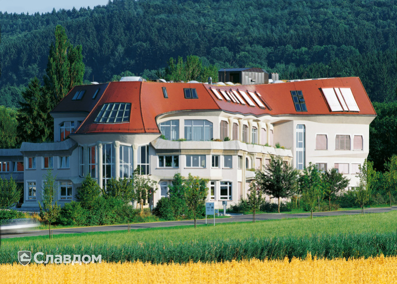 Многоэтажный дом в лесу с крышей из черепицы Creaton Biber Klassik Kupferrot engobiert